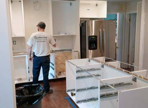 Kyle Swanson checking dimensions of kitchen cabinets